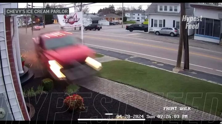 Truck narrowly misses SUV after crashing into ice cream parlor sign; no injuries reported.